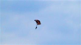 A paraglider descends to Perranprth Airport, as seen from the Coast Path